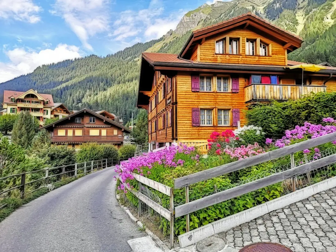 Façade de chalet en bois avec balcons fleuris